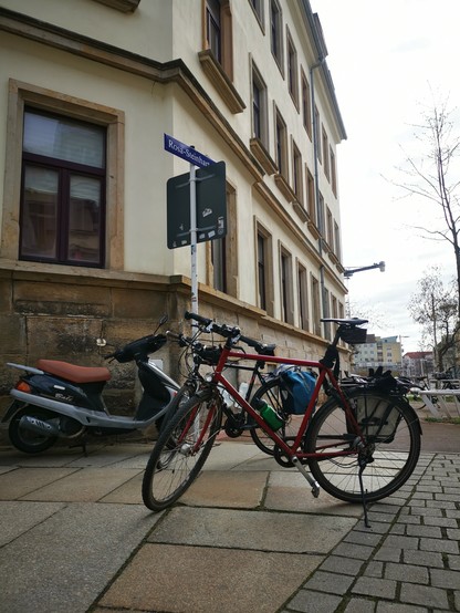 Zwei Fahrräder vor dem Straßenschild der Rosa Steinhart Straße. 
