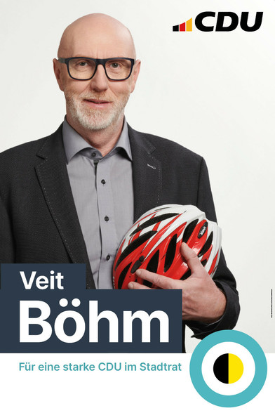 Wahlplakat von Veit Böhn, auf dem er mit Fahrradhelm im Arm abgebildet ist. 