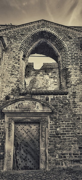 Ein Teil Ruine einer Kirche mit Türstock in monochrom. 