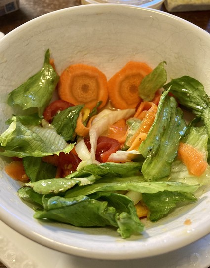 Ein bunter Salat mit Möhrenscheiben, die wie Augen im Salat wirken 