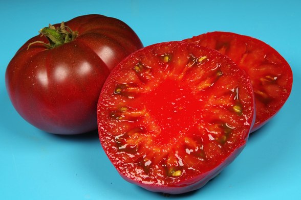 Zwei Tomaten, davon eine aufgeschnitten.