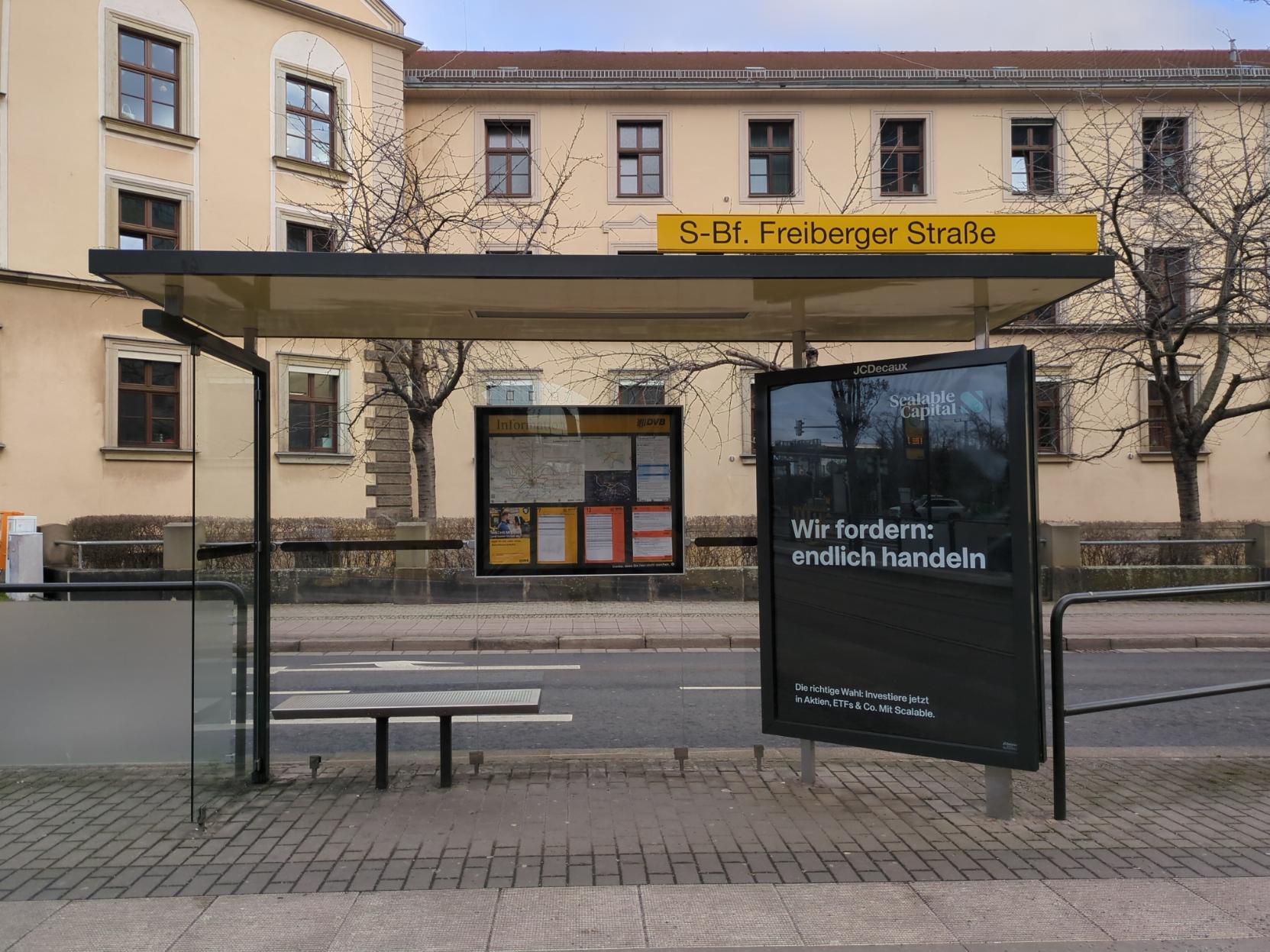 Eine der alten Haltestellen, auf deren Dach ein gelbes Schild mit dem Namen der Haltestelle "S-Bahnhof Freiberger Straße" montiert ist.
Rechts im Bild ist eine an die Haltestelle montierte Werbefläche mit dem Spruch "Wir fordern: endlich handeln". Eine der alten Haltestellen, auf deren Dach ein gelbes Schild mit dem Namen der Haltestelle "S-Bahnhof Freiberger Straße" montiert ist.
Rechts im Bild ist eine an die Haltestelle montierte Werbefläche mit dem Spruch "Wir fordern: endlich handeln".