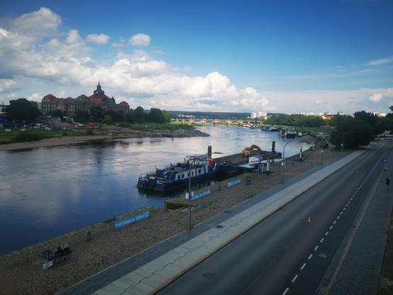 Blick von der Brühlschen Terrasse über das Dresdner Terrassenufer und die Elbe. Durch die fehlende Carolabrücke, von der nur noch Baustellenreste sichtbar sind, ist der Blick frei auf die dahinterliegende Albertbrücke. Auf der anderen Elbseite sind die Elbwiesen und die Sächsische Staatskanzlei erkennbar. 