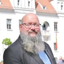 Ein Bild von René Jurisch, der in Meißen für die AfD als Bürgerinnenmeisterkandidat antritt. Er Trägt langen grauen Vollbart und Glatze. 