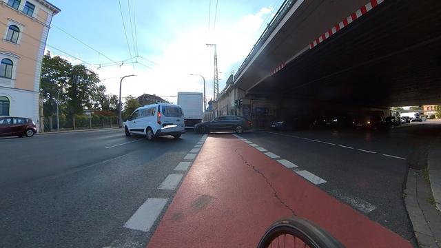 Ein Auto steht an einer Kreuzung quer über den Radweg und blockiert diesen. 
