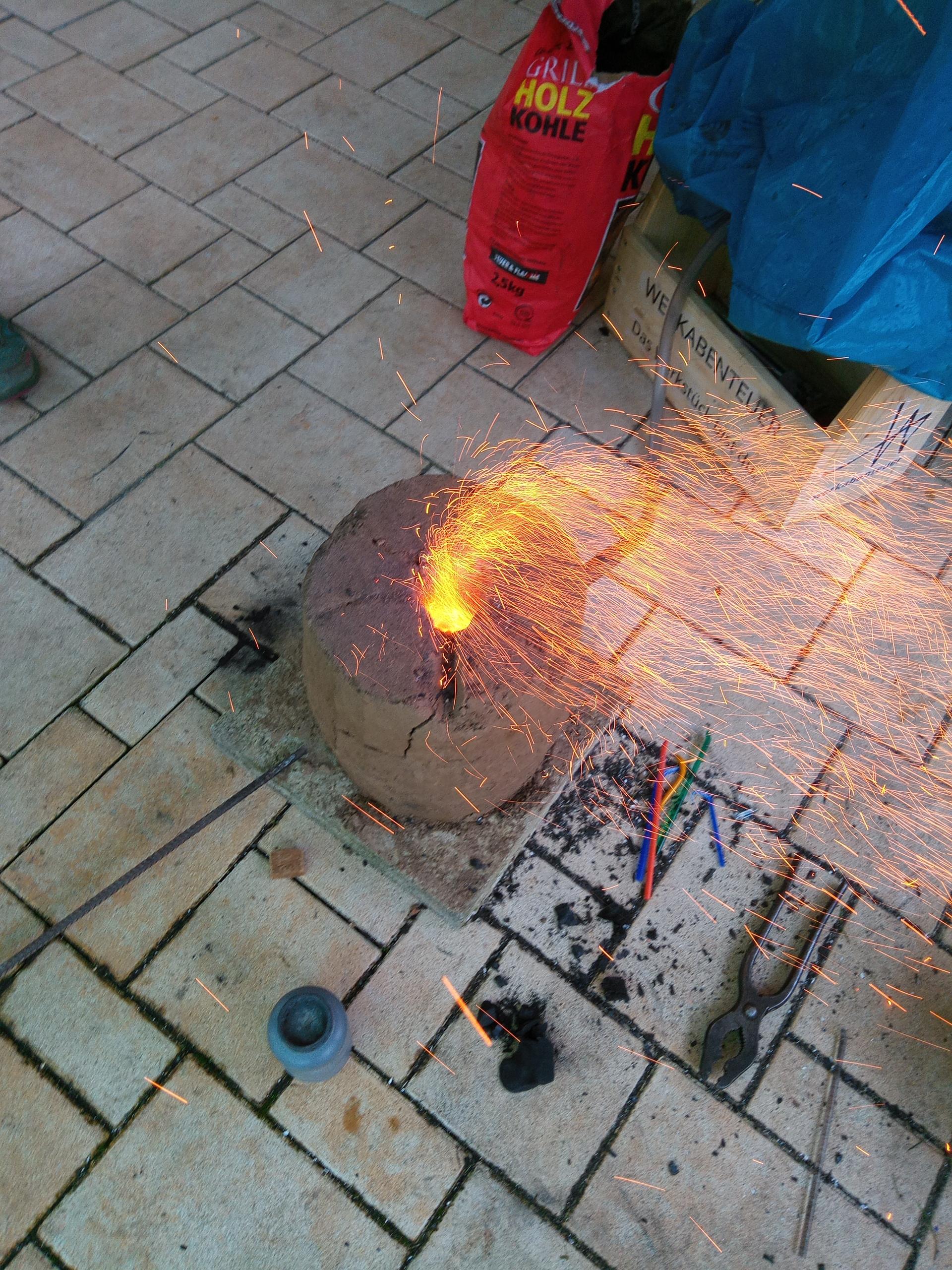 Der Lehmofen versprüht Funken wie ein Feuerwerk! Ich vermute, das liegt an einem Stück Holzkohle, das feucht war.