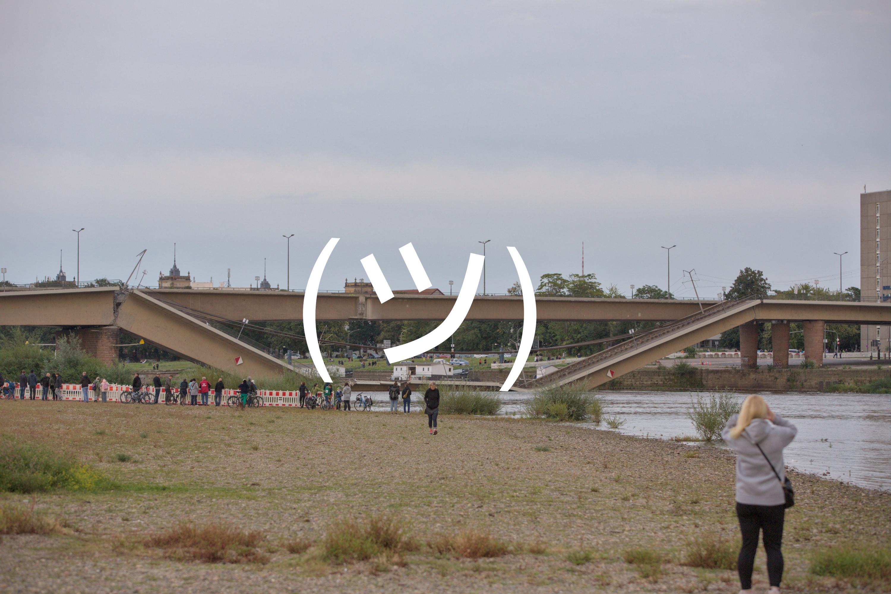 Die auf beiden Seiten abgeknickte Carolabrücke Zug C in Dresden. In der Mitte wurde noch ein Emoji eingefügt, sodass es zusammen mit der Brücke, das bekannte "Shrug Emoji" ¯\_(ツ)_/¯ ergibt.
