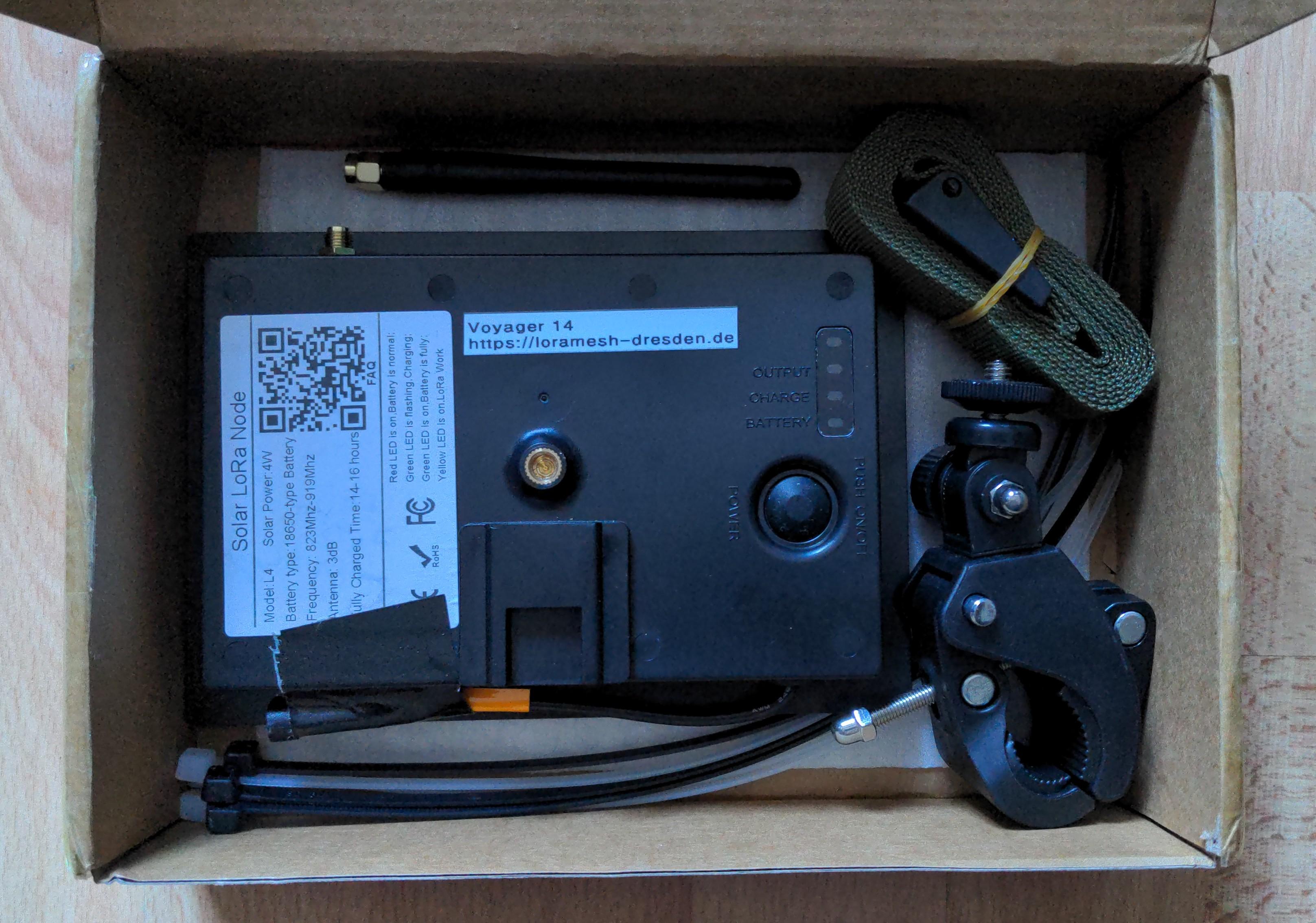 Gepackter Karton mit Repeater, Antenne, Klemme, Kabelbinder, Spanngurt.