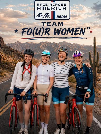 Vier lächelnde Radfahrerinnen stehen nebeneinander auf einer Straße in einer bergigen Wüstenlandschaft mit Kakteen im Hintergrund. Sie tragen Fahrradhelme und Sportkleidung und halten ihre Rennräder. Über ihnen sind das Logo des Race Across America und der Name des Teams "FO(U)R WOMEN“ abgebildet.