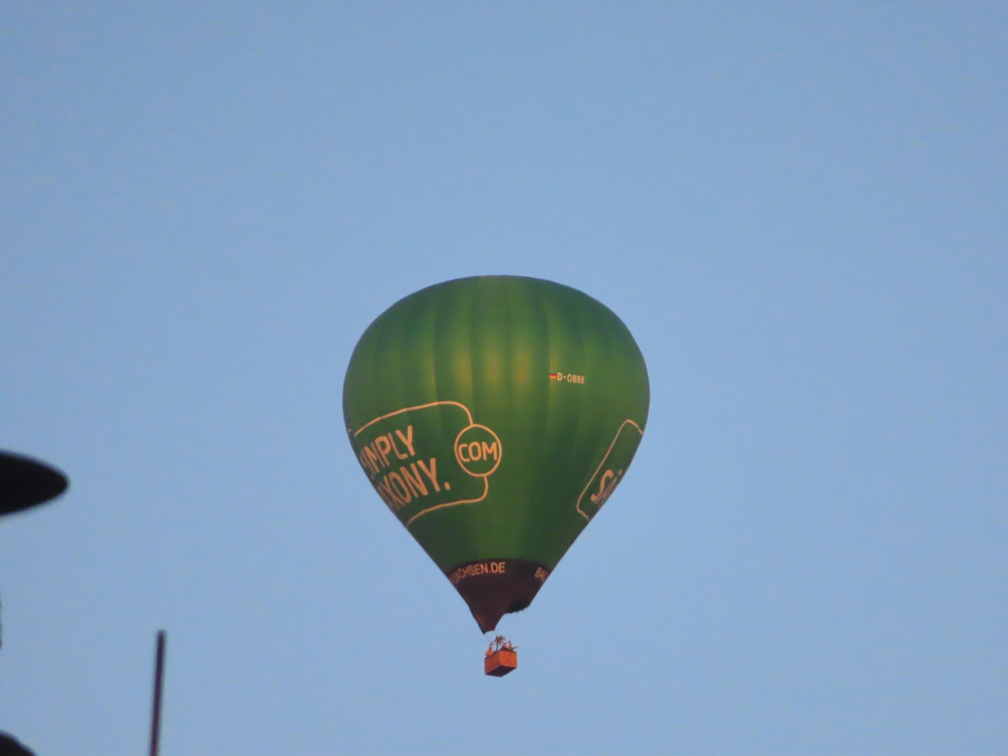 Grüner Heißluftballon am helleren Morgenhimmel