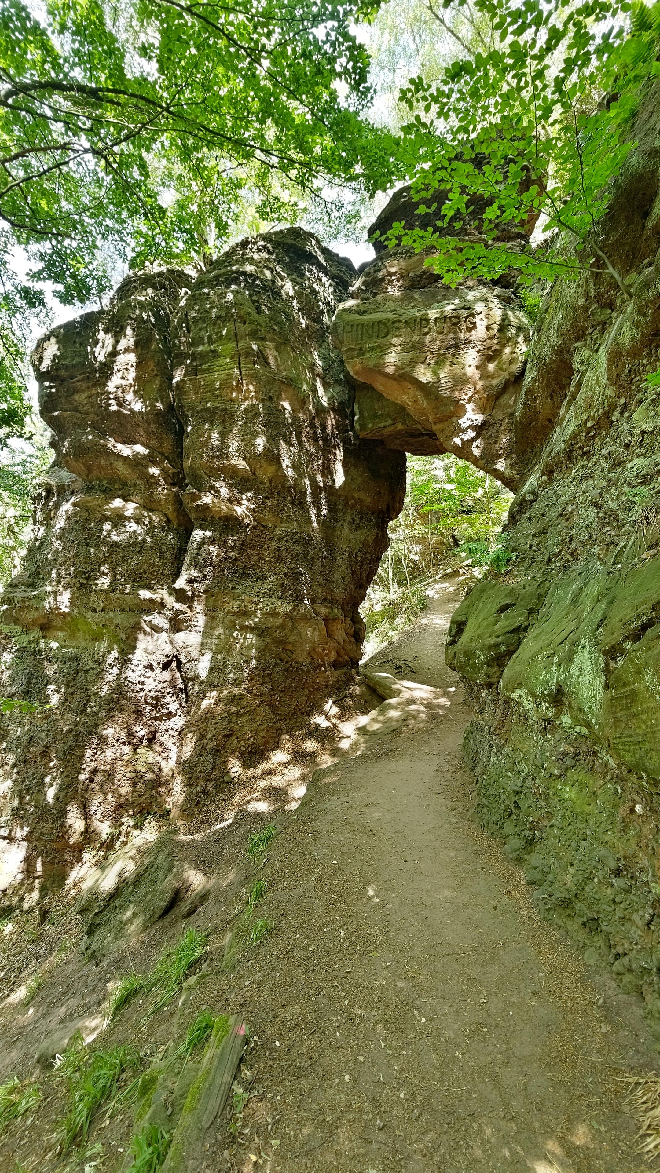 Ein Sandsteinbogen durch den ein Weg führt. Im oberen Teil ist das Wort Hindenburg eingemeißelt.