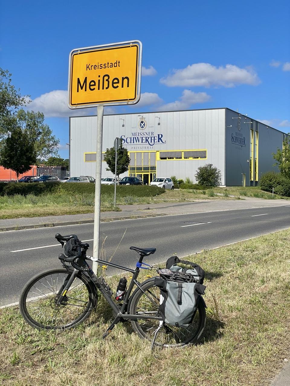 Mein Fahrrad am Ortseingangsschild der Kreisstadt Meißen
Im Hintergrund ein mit
Seit 1460
Meissner Schwerter ⚔️ 
Privatbrauerei 
beschriftetes Gebäude